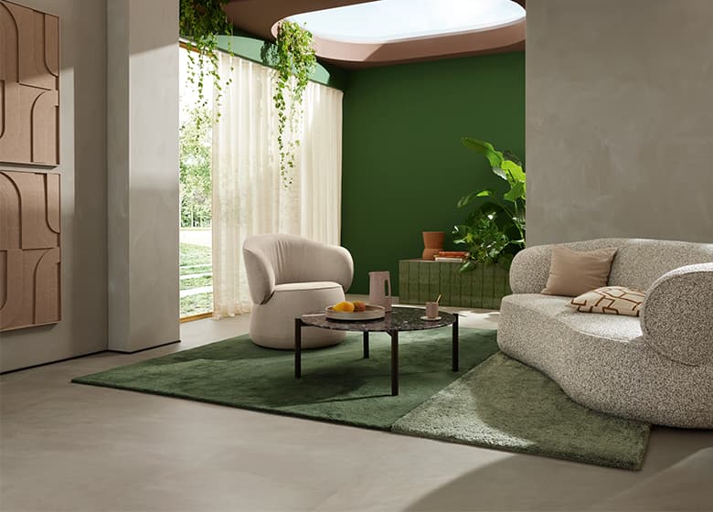Sessel und Sofa Nimbo auf einem grünen Teppich.