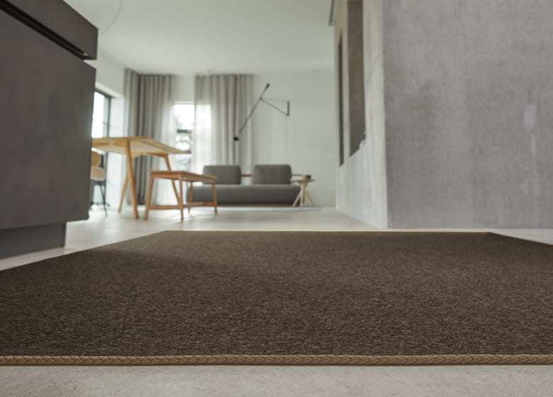 brauner Filzteppich mit Lederkordel im Wohnzimmer