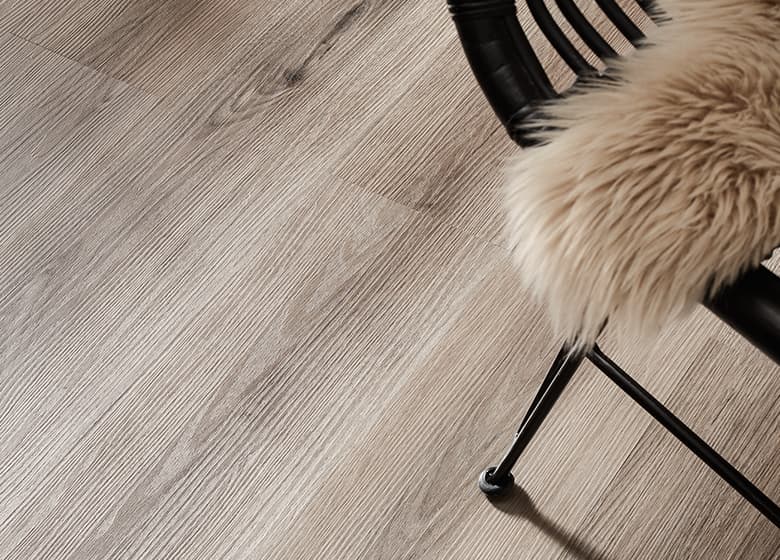 Das Bild zeigt einen Holz-Designboden, der mit einer Prägung versehen ist, die die natürliche Textur und Maserung von Holz nachahmt.