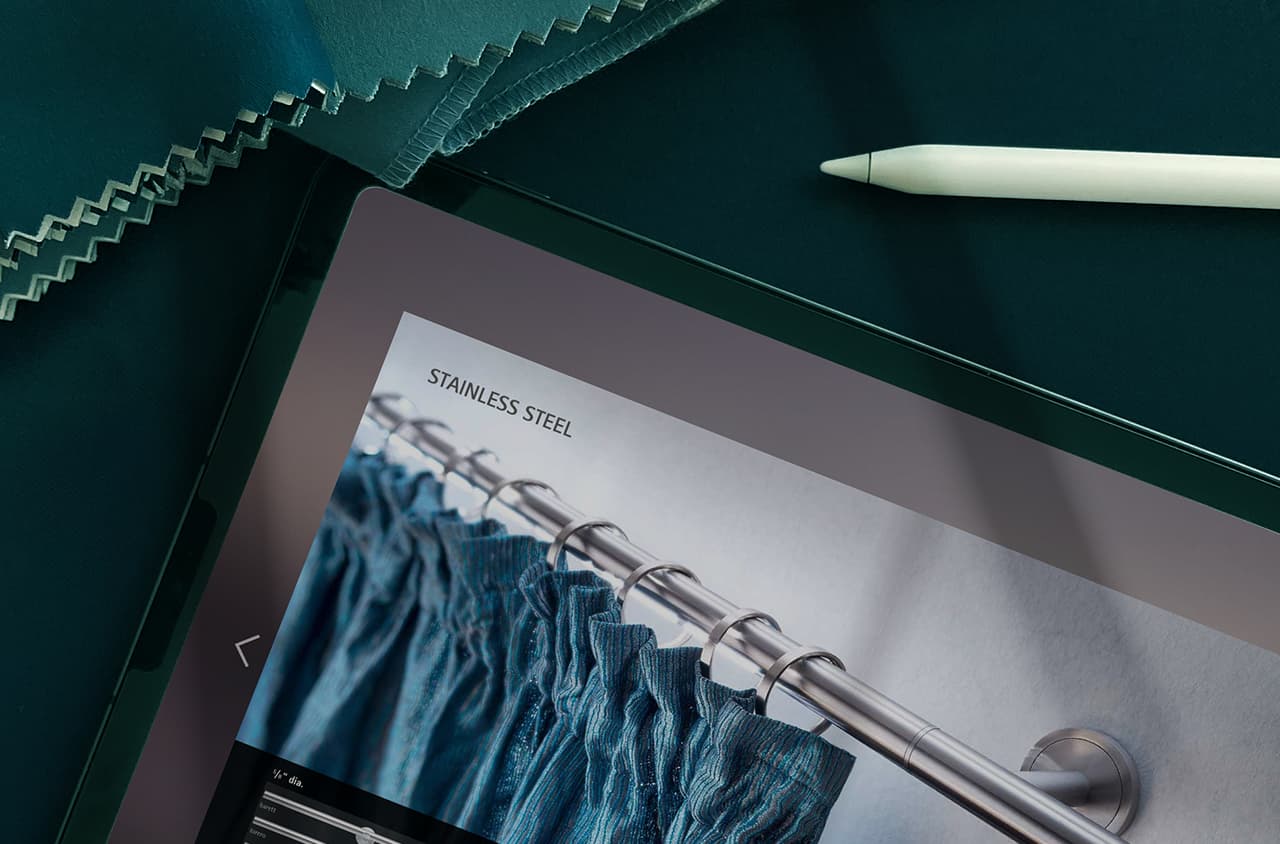 Tablet screen showing stainless steel curtain rod with blue curtains, teal fabric samples, white stylus.