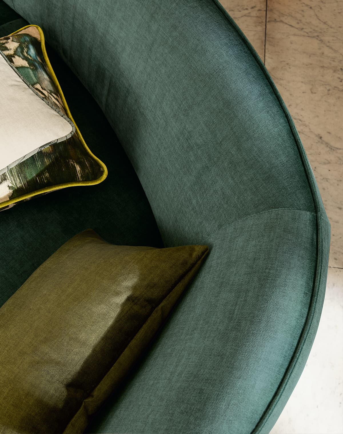 Ein grünes Sofa mit drei Kissen.