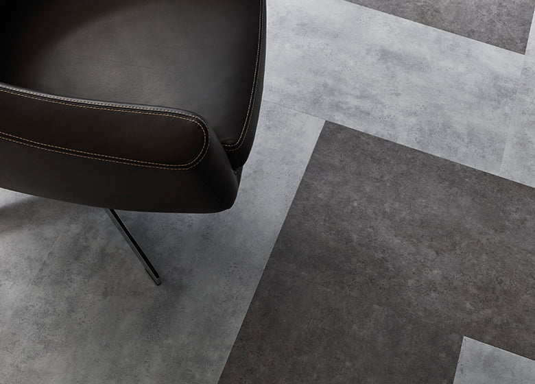Detailaufnahme Designfloor LVT in Steinoptik darauf ein Sessel