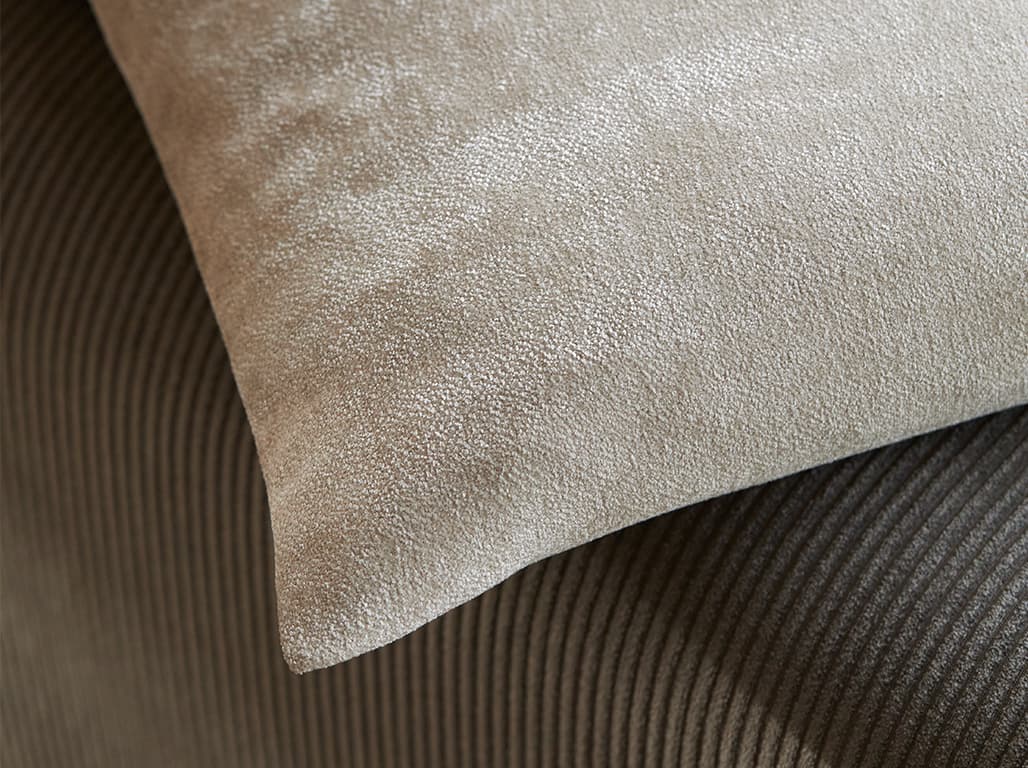 Hellbraunes Kissen auf braunem Sofa