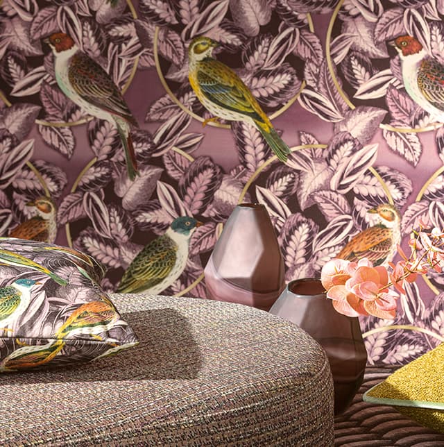 Grauer Pouf vor Tapete mit Motiv