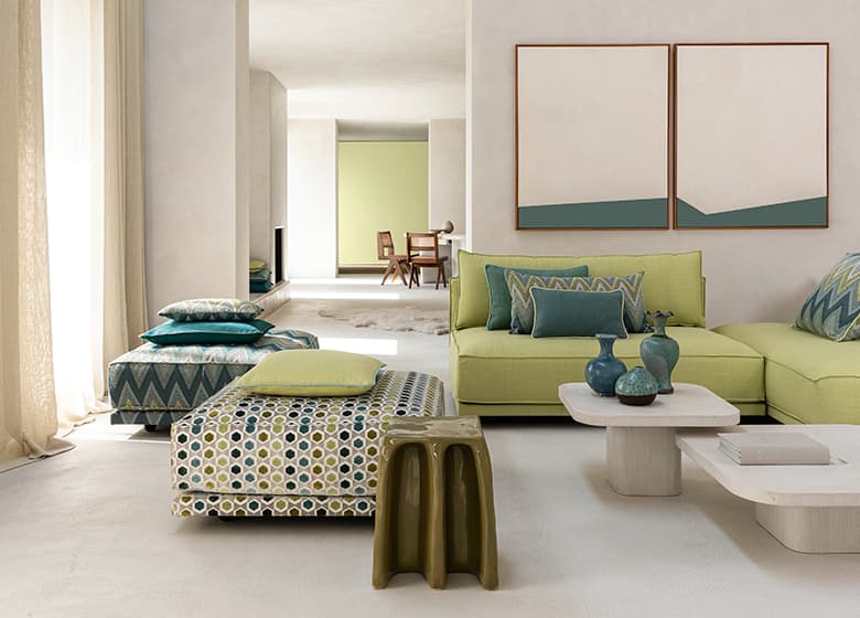 2 Sitzelemente mit Mustern und ein grünes Sofa.