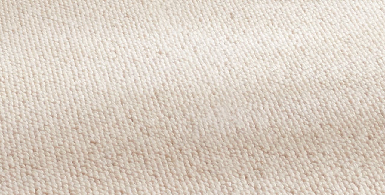 Eine Detailaufnahme von einem hellen Teppich.