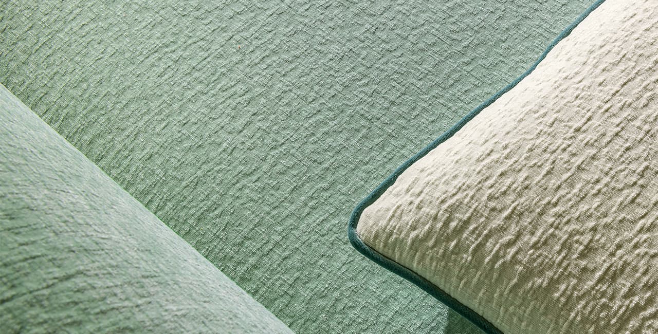 Ein weißes Kissen auf einem grünen Sofa