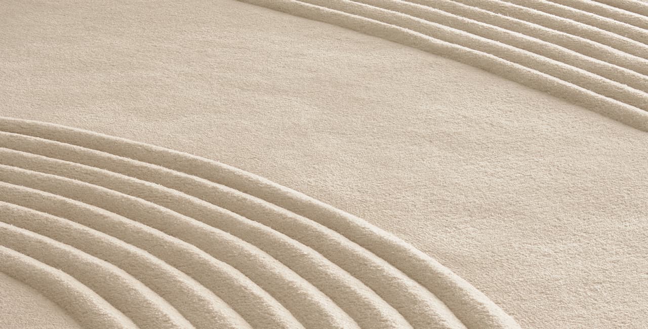 beiges Teppichdesign, das durch verschiedene Florhöhen einen Zen-Garten nachahmt