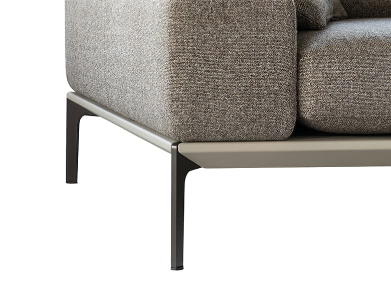 Nahaufnahme von Füßen in bronze matt eines beigen Sofas.