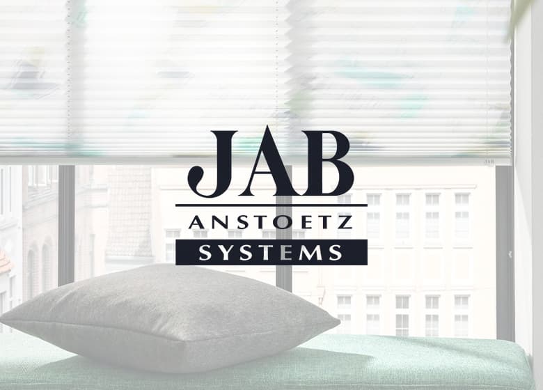 Eine Aufnahme von Plissees und davor ist das Systems-Logo.