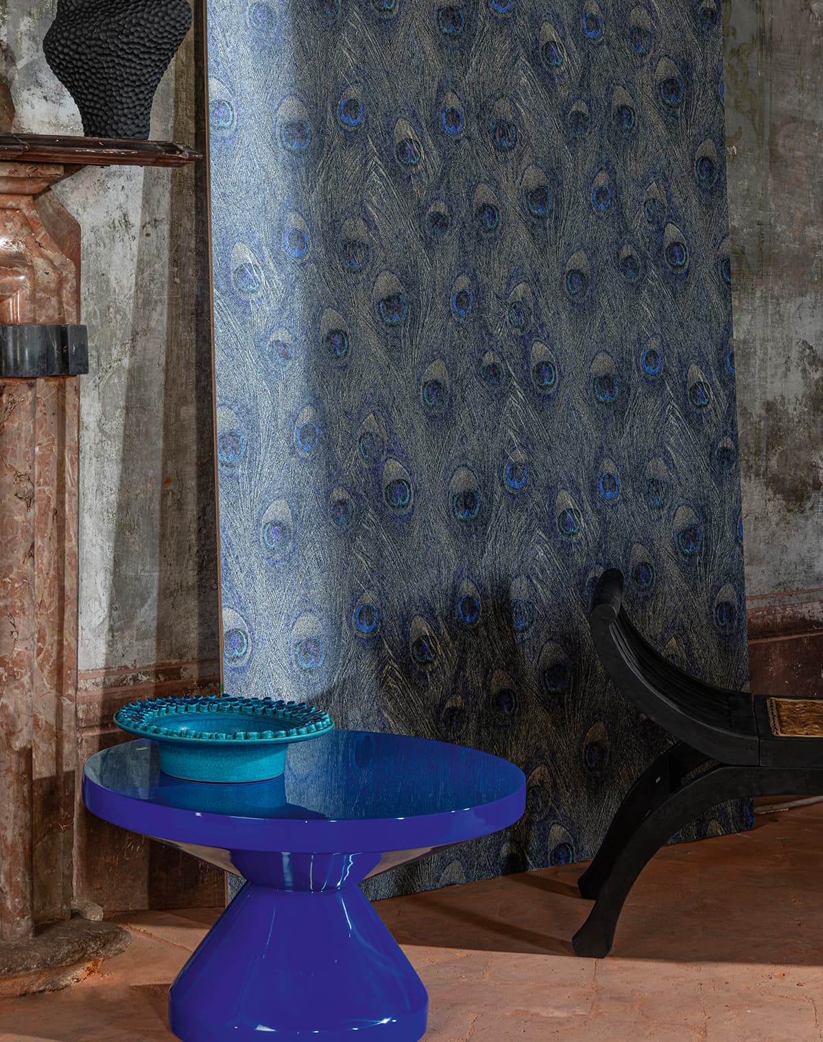 Ein blauer Tisch und eine Tapete mit Pfauenfeder-Design