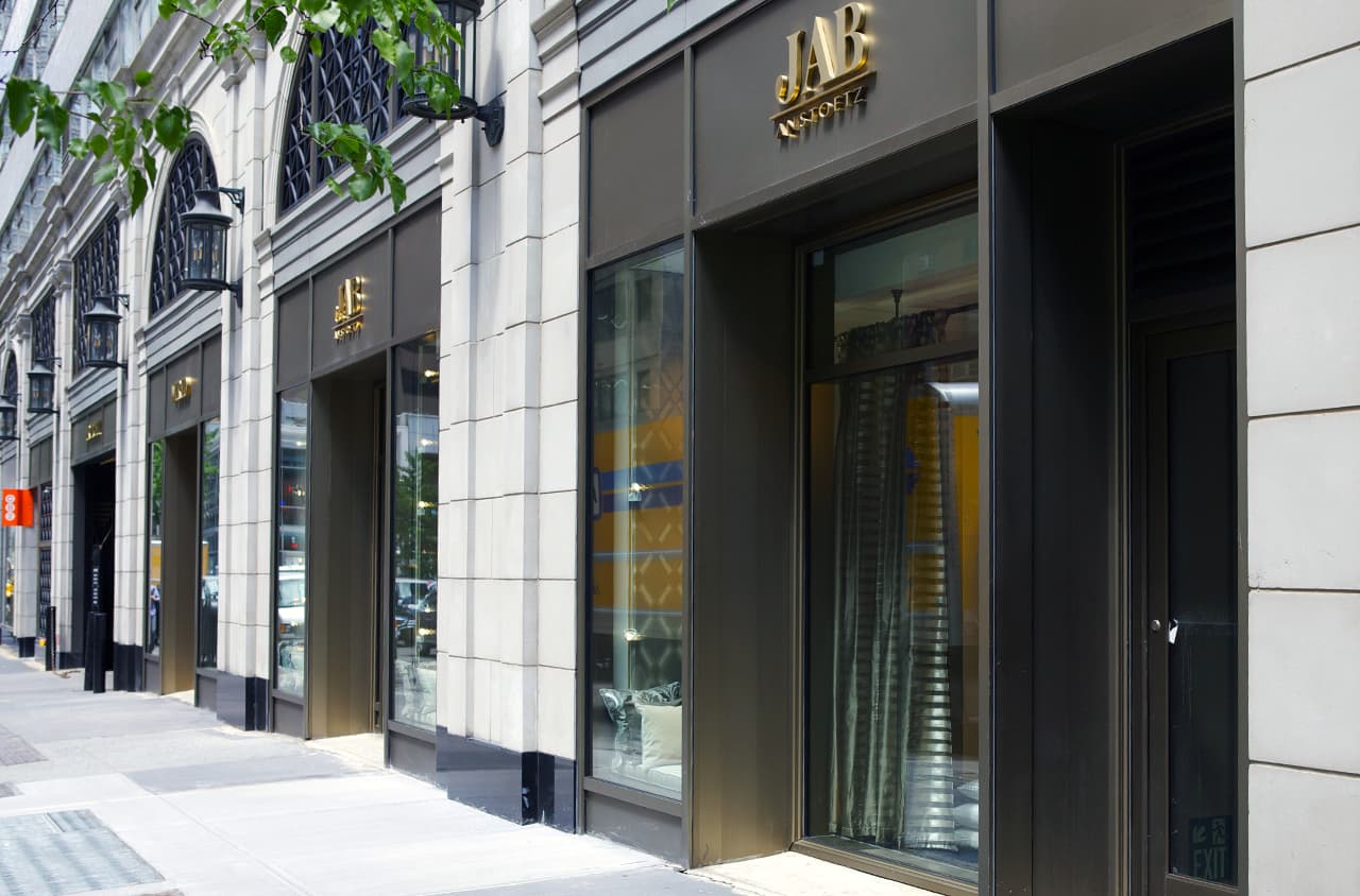 JAB ANSTOETZ city storefronts with gold signage and large windows.