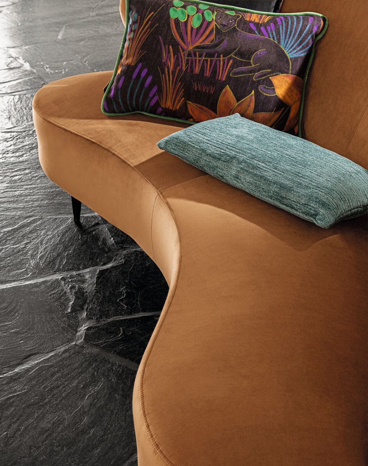 Orangenes Sofa und ein Kissen mit Jungle-Print